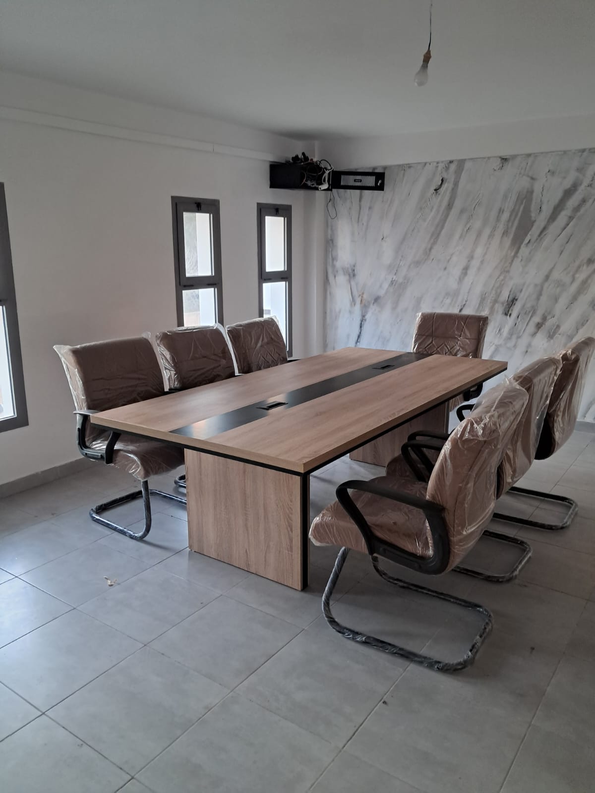 Grande table de réunion avec sièges visiteurs capitonnés.