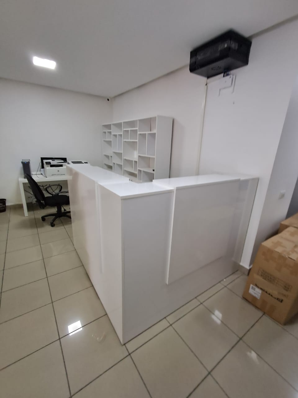 Comptoir d’accueil blanc avec poste de travail.